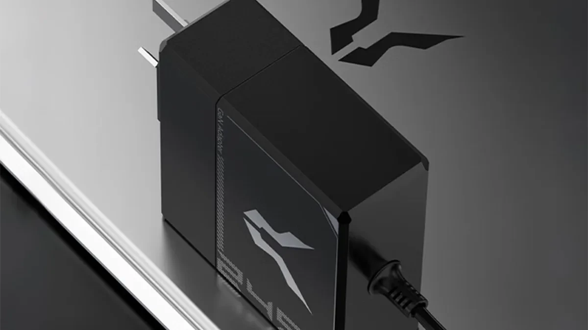Pengisi daya Lenovo Lecoo Bellator 245W berada di atas laptop dengan kabel DC 5525
